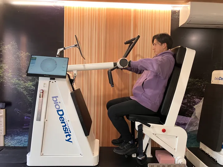 機械に座り、腕で前に押す動作